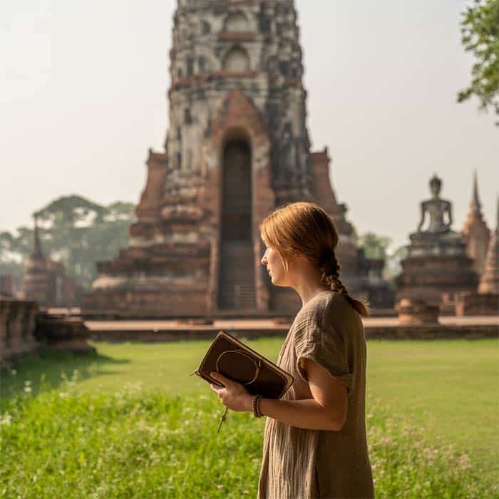 A solo traveler exploring the historical ruins of Ayutthaya, Thailand.